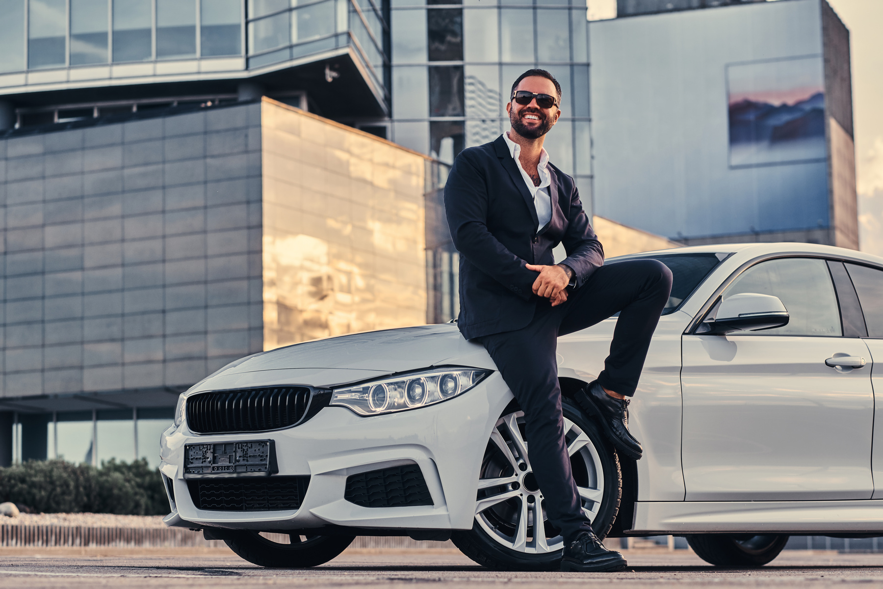 Happy Handsome Bearded Male in Sunglasses Dressed in a Black Sui